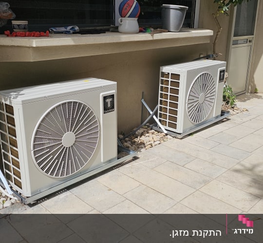 שתי יחידות חיצוניות של מזגן מותקן על הקרקע